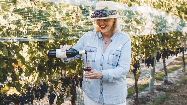 Woman pouring wine in vineyard