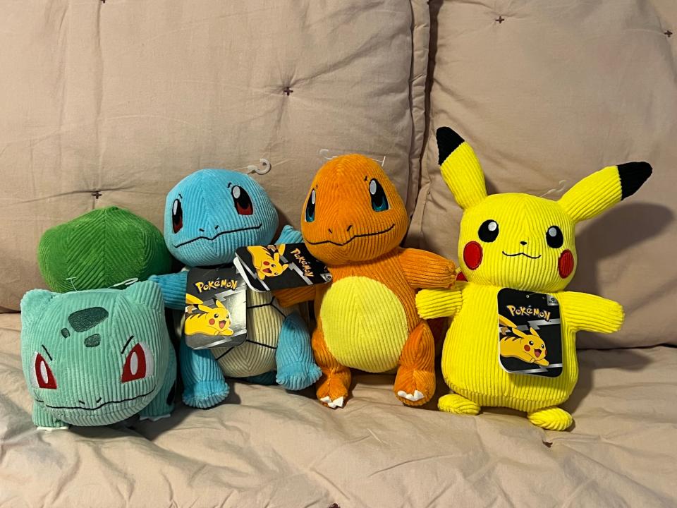 a corduroy plush bulbasaur, charmander, pikachu, and squirtle.