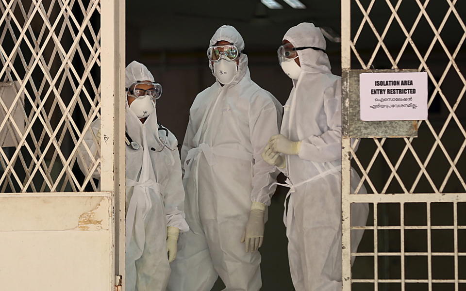 Medical staff wearing full protective suits stand at the entrance to the isolated ward of the Ernakulam Government Medical College in Kochi, Kerala, India. Source: EPA via AAP