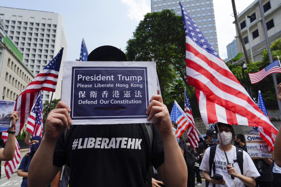 Protesters waves United States flags and placards during a protest in Hong Kong, Sunday, Sept. 8, 2019. Demonstrators in Hong Kong plan to march to the U.S. Consulate on Sunday to drum up international support for their protest movement, a day after attempts to disrupt transportation to the airport were thwarted by police. (AP Photo/Vincent Yu)