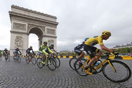 Team Sky rider Chris Froome of Britain (R), the race leader's yellow jersey, cycles near the Arc de Triomphe during the 109.5-km (68 miles) final 21st stage of the 102nd Tour de France cycling race from Sevres to Paris Champs-Elysees, France, July 26, 2015. REUTERS/Pascal Rossignol