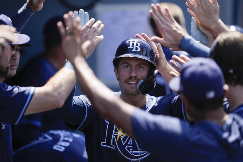 Tampa Bay Rays' Jonny DeLuca celebrates in the dugout after hitting a home run during the seventh inning of a baseball game against the Los Angeles Dodgers in Los Angeles, Sunday, Aug. 25, 2024. (AP Photo/Ashley Landis)