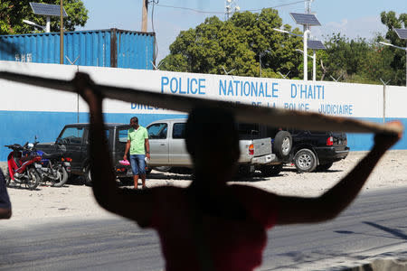 A woman carries a deck in front of a main Haitian police station, where according to local media a group of foreign nationals including Americans armed with semi-automatic weapons were detained, after anti-government protests, in Port-au-Prince, Haiti, February 18, 2019. REUTERS/Ivan Alvarado