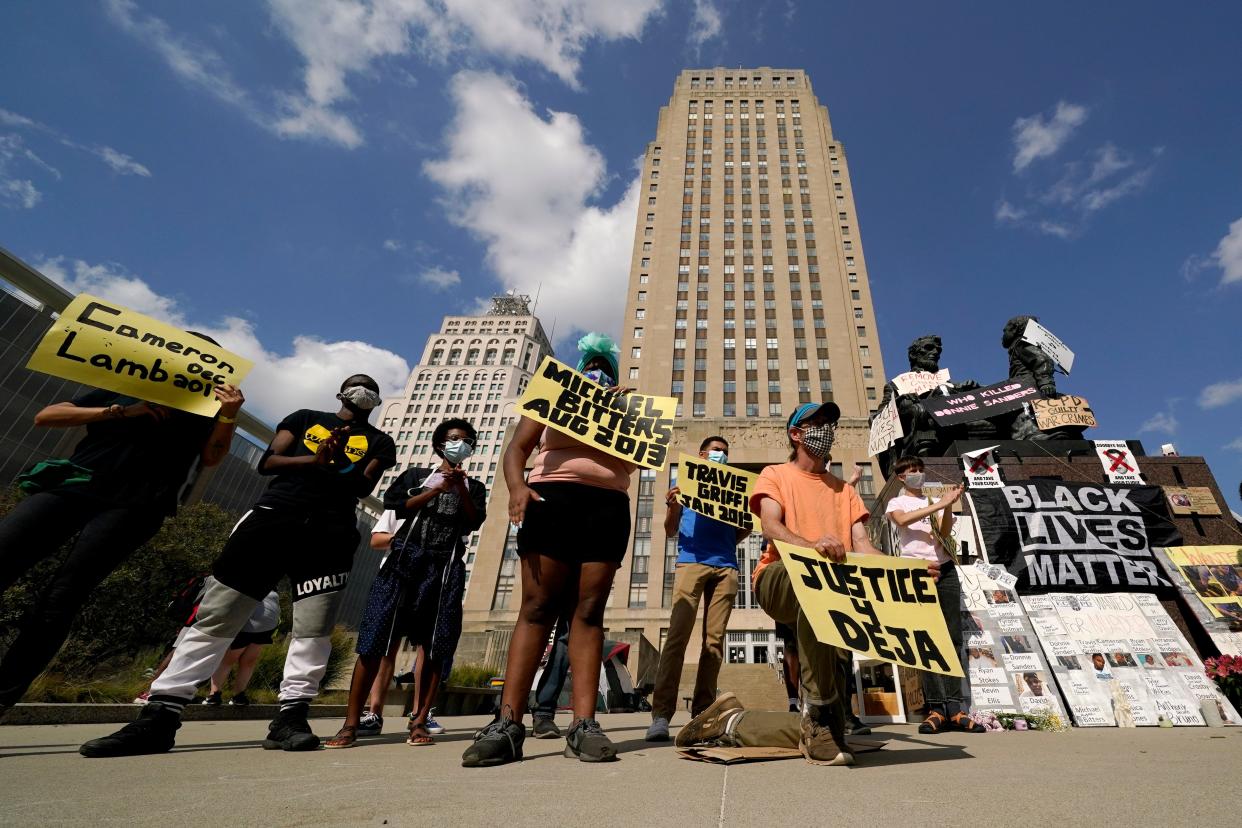 Protesters hold signs outside city hall Thursday, Oct. 8, 2020, in Kansas City, Mo., demanding the resignation of an officer who knelt on the back of nine-months-pregnant Black woman, Deja Stallings, while arresting her the previous week, and Police Chief Rick Smith. (AP Photo/Charlie Riedel) ORG XMIT: MOCR114