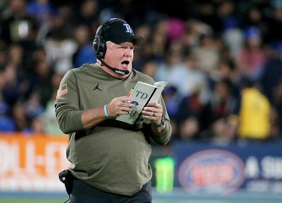 UCLA coach Chip Kelly looks at his play card and shouts on the sideline during the Bruins' loss to Arizona State