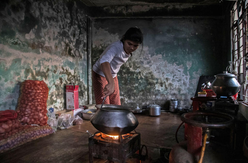 A police officer who fled Myanmar following a military coup cooks a meal at an undisclosed location bordering Myanmar, in the northeastern Indian state of Mizoram, Thursday, March 18, 2021. Villagers in Mizoram have given shelter to 34 Myanmar police personnel and 1 fire fighter, who crossed over to the state over the last two weeks. Those who escaped spend their time watching local television and doing daily chores. Some of them have carried mobile phones and are trying to connect to families they were forced to leave behind. At night, all of them go to sleep on mattresses laid on the floor of a single room. (AP Photo/Anupam Nath)