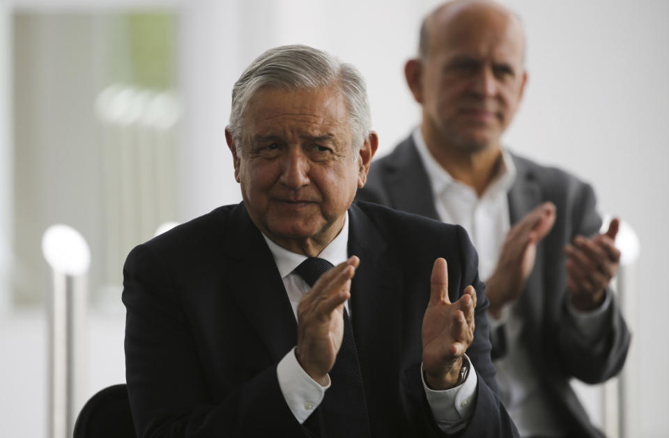 Mexico's President Andres Manuel Lopez Obrador, left, applauds prior to delivering a speech during his visit to a public hospital in Cuernavaca, Mexico, Friday, June 19, 2020. Lopez Obrador is desperate to restart Mexico's struggling economy after being cooped up under social distancing measures due to the new coronavirus pandemic. (AP Photo/Fernando Llano)