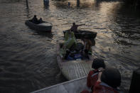 Rescue workers attempt to tow boats carrying residents being evacuated from a flooded neighborhood in Kherson, Ukraine, Tuesday, June 6, 2023. The wall of a major dam in a part of southern Ukraine has collapsed, triggering floods, endangering Europe's largest nuclear power plant and threatening drinking water supplies. (AP Photo/Felipe Dana)