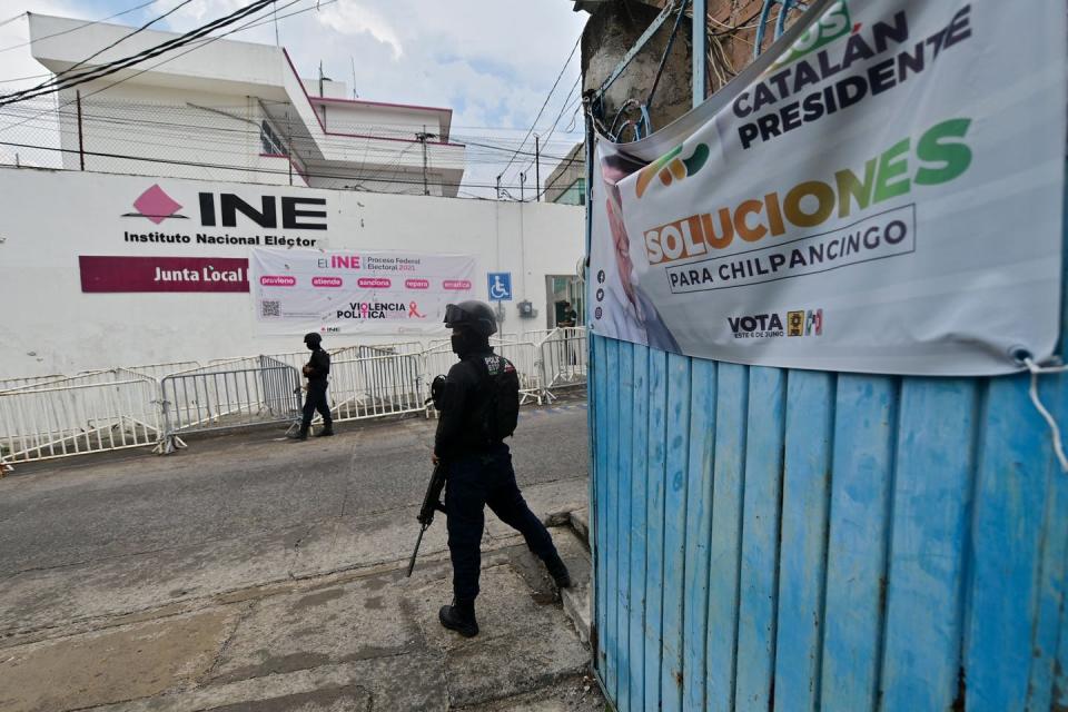 Armed policemen stand outside a building