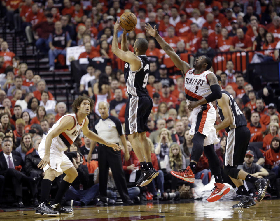 San Antonio Spurs' Tony Parker (9) shoots as Portland Trail Blazers' Robin Lopez (42) and Wesley Matthews (2) defend in the first quarter during Game 3 of a Western Conference semifinal NBA basketball playoff series Saturday, May 10, 2014, in Portland, Ore. (AP Photo/Rick Bowmer)