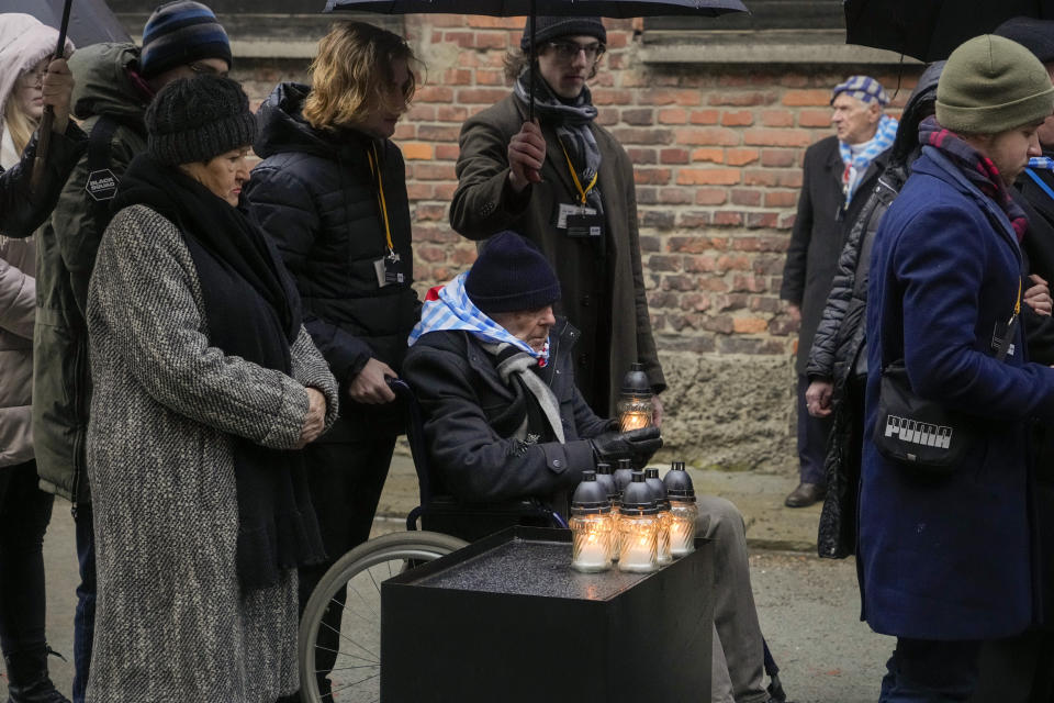 A Holocaust survivor holds a candle while waiting in line to place it next to the Death Wall at the Auschwitz Nazi death camp in Oswiecim, Poland, Saturday, Jan. 27, 2024. Survivors of Nazi death camps marked the 79th anniversary of the liberation of the Auschwitz-Birkenau camp during World War II in a modest ceremony in southern Poland.(AP Photo/Czarek Sokolowski)