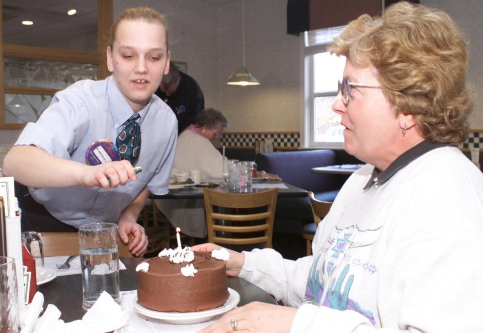In this 2002 photo, Andrea Mann lights a birthday cake for Margaret Quick at Bill Knapp's Restaurant in Battle Creek.