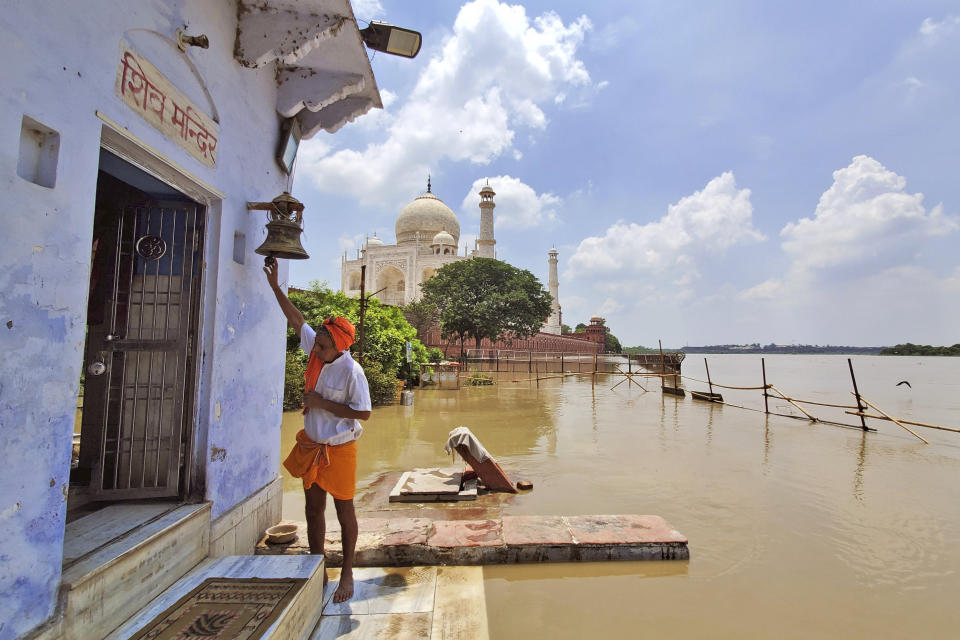 A man worships at a temple of Hindu god Shiva standing next to a swollen Yamuna river flowing up to the periphery of the Taj Mahal monument in Agra, India, Wednesday, July 19, 2023. India regularly witnesses severe floods during the monsoon season, which runs between June and September and brings most of South Asia’s annual rainfall. (AP Photo/Aryan Kaushik)