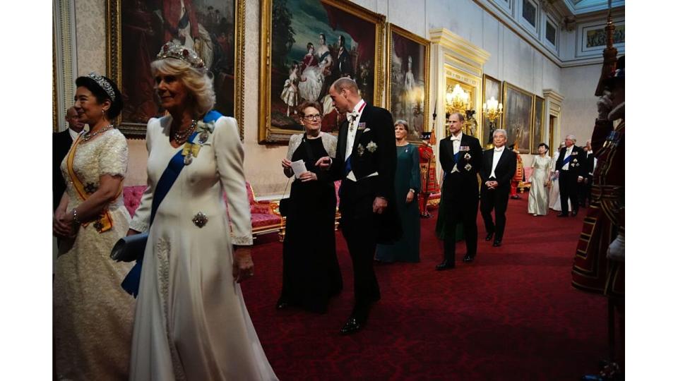 Prince William and a woman walking behind Queen Camilla and Empress Masako