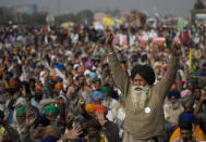 An elderly farmer shouts slogans as others listen to a speaker as they block a major highway during a protest to abolish new farming laws they say will result in exploitation by corporations, eventually rendering them landless, at the Delhi-Haryana state border, India, Tuesday, Dec. 1, 2020. The busy, nonstop, arterial highways that connect most northern Indian towns to this city of 29 million people, now beat to the rhythm of never-heard-before cries of "Inquilab Zindabad" ("Long live the revolution"). Tens and thousands of farmers, with colorful distinctive turbans and long, flowing beards, have descended upon its borders where they commandeer wide swathes of roads. (AP Photo/Altaf Qadri)