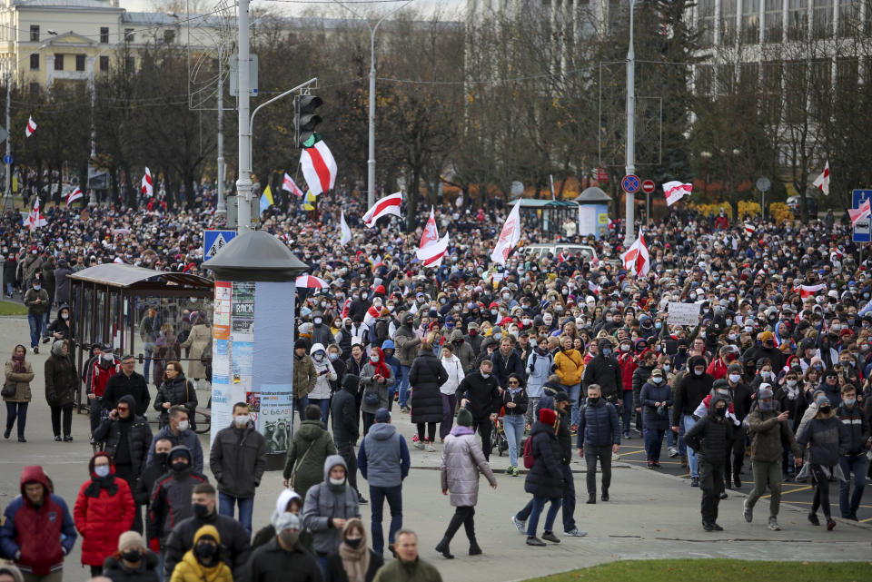 Demonstrators with old Belarusian national flags march during an opposition rally to protest the official presidential election results in Minsk, Belarus, Sunday, Nov. 1, 2020. Some thousands of protesters swarmed the streets of the Belarus' capital on Sunday, demanding the resignation of the country's longtime authoritarian leader, and were met with police firing warning shots into the air and using stun grenades to break up the crowds. (AP Photo)
