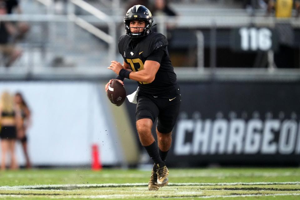 UCF Knights quarterback Mikey Keene (13) rolls out of the pocket in the fourth quarter during a college football game against the Cincinnati Bearcats, Saturday, Oct. 29, 2022, at FBC Mortgage Stadium in Orlando, Fla. The UCF Knights defeated the Cincinnati Bearcats, 25-21. 