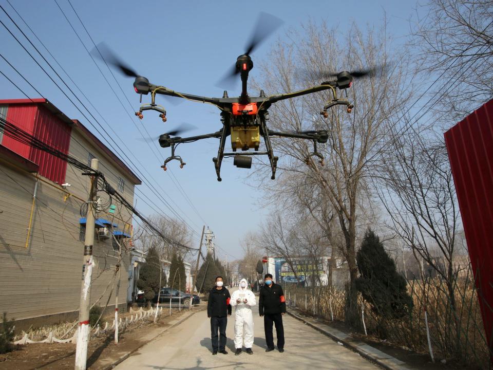 A volunteer in protective suits controls a drone to spray disinfectants at Zhengwan village, amid coronavirus, in Handan, Hebei province, China January 31, 2020. China Daily via REUTERS .JPG