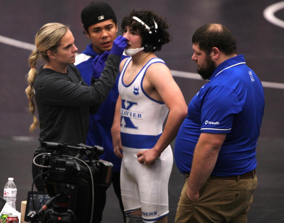 St. Xavier freshman Kane Shawger gets his nose examined in the 132 final during the championship finals of the Southwest Ohio Wrestling Coaches Association Coaches Classic wrestling tournament Dec. 23, 2023 at Middletown High School's arena.
