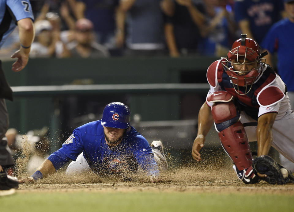 Chicago Cubs' David Bote, left, slides home to score on a single by Taylor Davis against Washington Nationals catcher Pedro Severino during the 10th inning of a baseball game Thursday, Sept. 6, 2018, in Washington. The Cubs won 6-4. (AP Photo/Nick Wass)