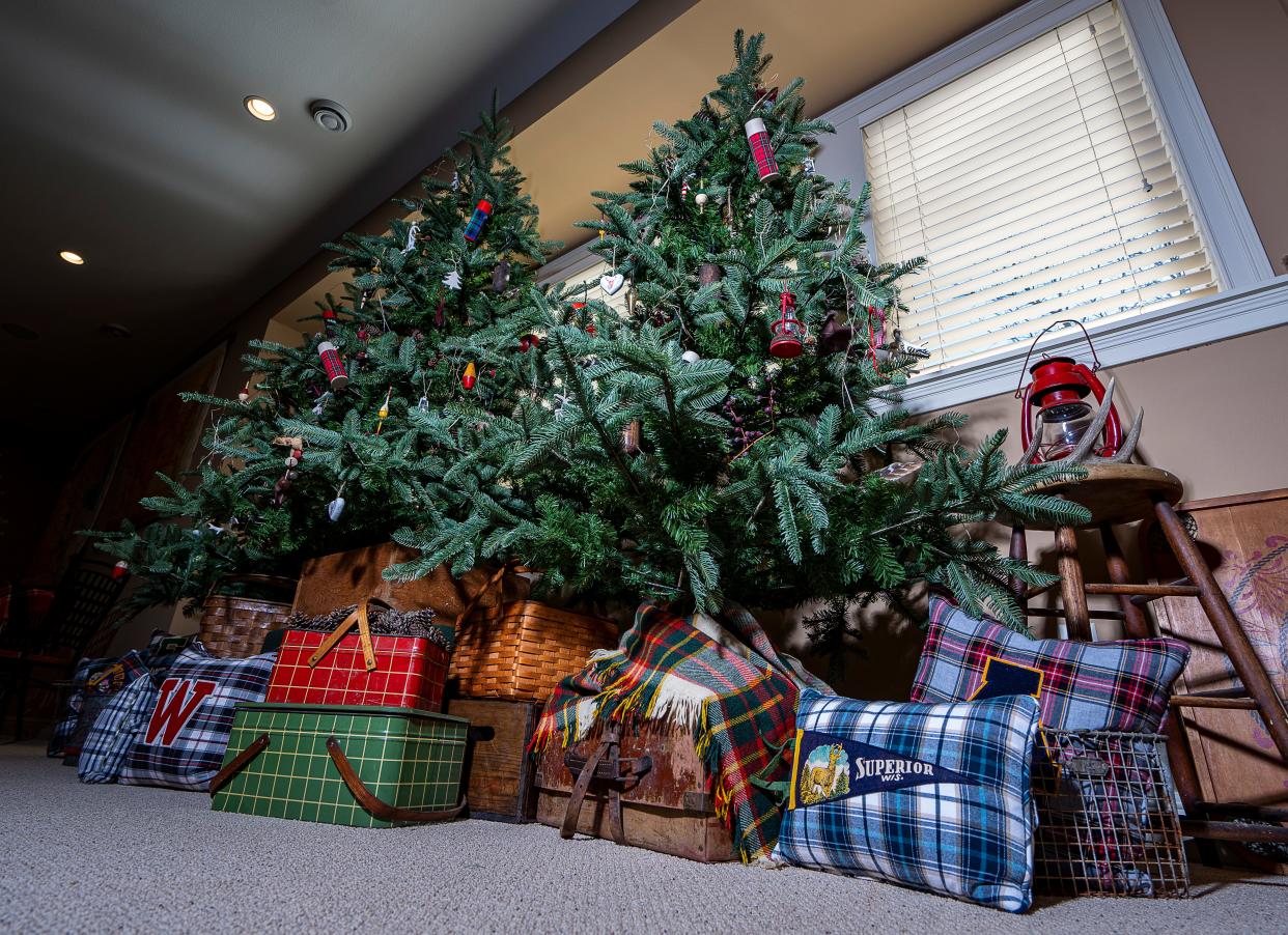 Three faux trees are surrounded by pillows made by Julie Hunt in her home's rec room.