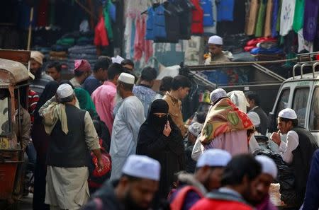 A muslim woman speaks on her mobile phone as she walks through a market in Delhi, India December 14, 2016. REUTERS/Cathal McNaughton