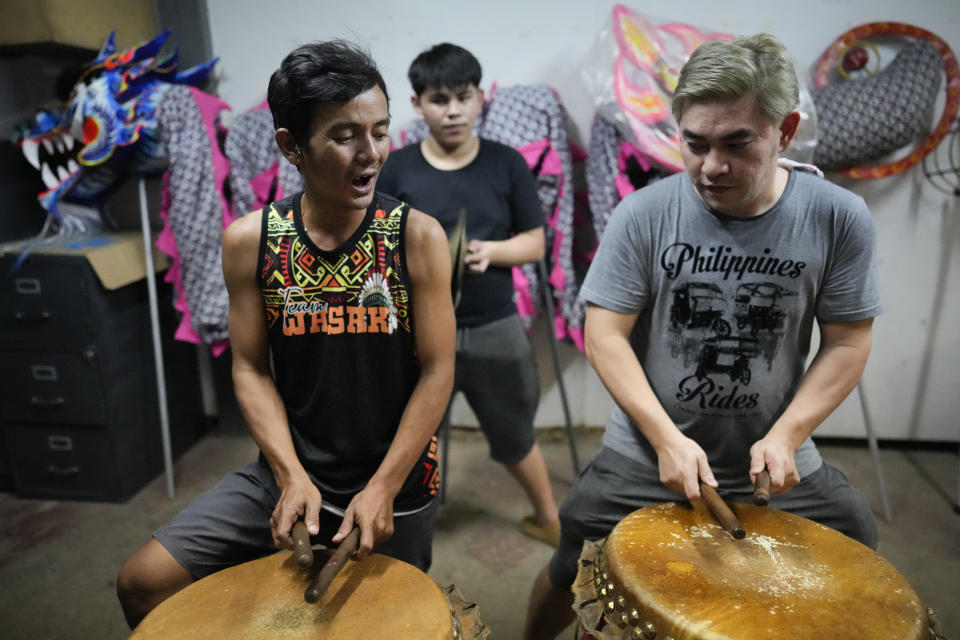 Performers practice their routine at Binondo district, said to be the oldest Chinatown in the world, in Manila, Philippines on Tuesday Feb. 6, 2024, Crowds are flocking to Manila's Chinatown to usher in the Year of the Wood Dragon and experience lively traditional dances on lantern-lit streets with food, lucky charms and prayers for good fortune. (AP Photo/Aaron Favila)