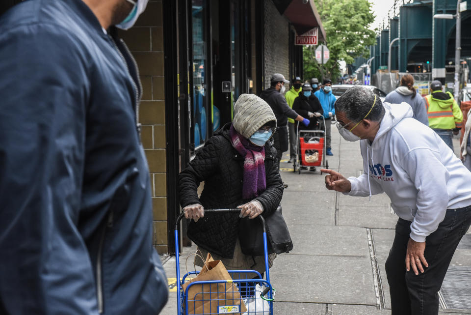 NEW YORK, NY - MAY 11: A person explains how the food line  operates for food donated by SOMOS, in partnership with World Central Kitchen and Maestro Cares Foundation on May 11, 2020 in the Elmhurst neighborhood in the Queens borough in New York City. Some people who waited since 6 am stated that this Monday food distribution is popular because raw fruits and vegetables to cook are given out, not only pre-made meals. (Photo by Stephanie Keith/Getty Images)