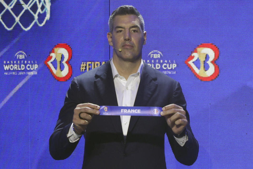 FIBA ambassador and former NBA star Luis Scola holds the ticket for France national basketball team during the FIBA World Cup 2023 draw in Quezon city, Philippines on Saturday April 29, 2023. (AP Photo/Josefino de Guzman)