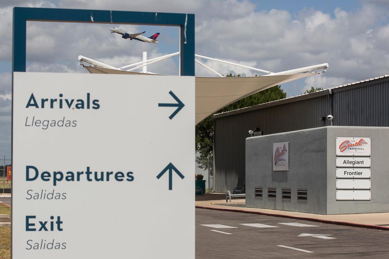 A plane flies above Austin-Bergstrom International Airport's South Terminal last June. The city plans to eventually replace the South Terminal with new infrastructure for a midfield concourse, which will connect to the main terminal through an underground tunnel.