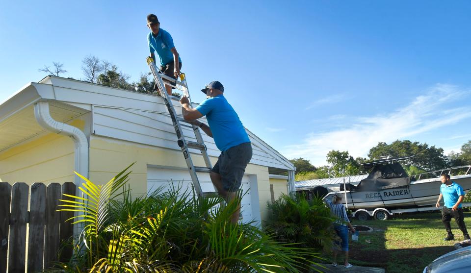 A crew from DR Roofers in Palm Bay inspects a roof Friday morning on Hoover Street in the aftermath of the EF0 tornado that struck north of Sarno Road in Melbourne.