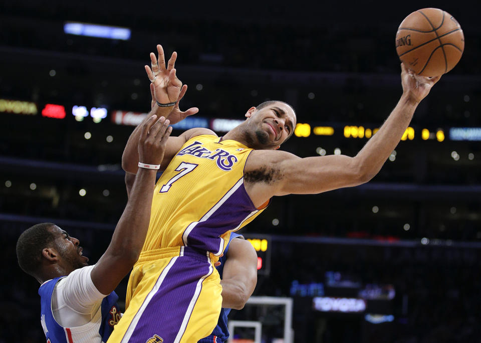 Los Angeles Lakers' Xavier Henry, center, passes the ball as he is defended by Los Angeles Clippers' Chris Paul during the first half of an NBA basketball game on Thursday, March 6, 2014, in Los Angeles. (AP Photo/Jae C. Hong)