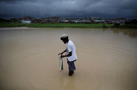 A Rohingya refugee washes a bag in contaminated water in Cox's Bazar, Bangladesh, September 28, 2017. REUTERS/Cathal McNaughton