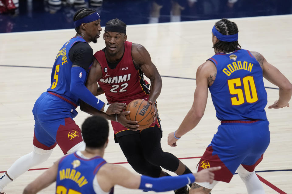 Miami Heat forward Jimmy Butler (22) is defended by Denver Nuggets guard Kentavious Caldwell-Pope, left, during the first half of Game 1 of basketball's NBA Finals, Thursday, June 1, 2023, in Denver. (AP Photo/David Zalubowski)