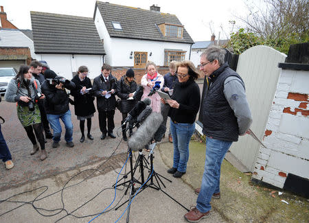 Dee Milligan-Bott (2nd R) co-owner of Irish setter Jagger and her husband Jeremy Bott (R) speak to members of the media outside their home in Kilby, central England March 9, 2015. REUTERS/Stringer