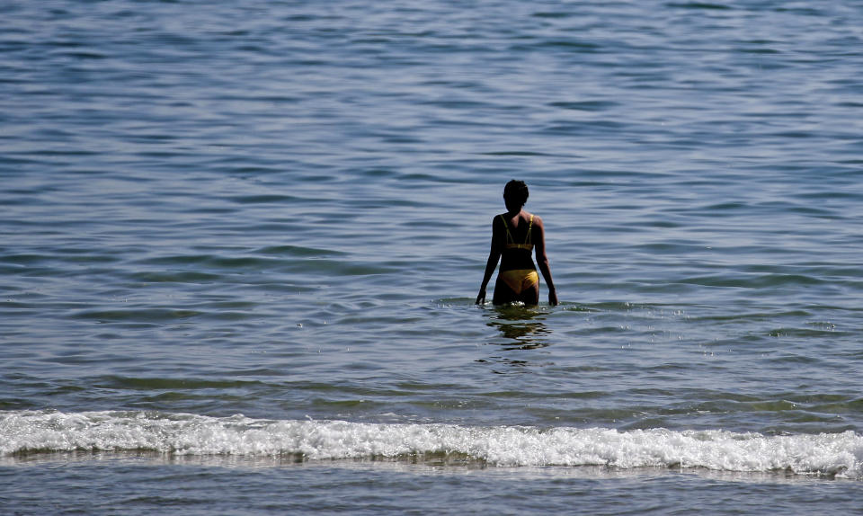 <p>A woman wades out into the sea at Bournemouth beach in Dorset. Picture date: Monday April 19, 2021.</p>
