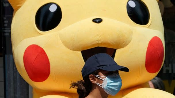 PHOTO: A young person wearing a mask for COVID-19 protection walks past a Pikachu mascot at Times Square on July 22, 2021 in New York.  (Timothy A. Clary/AFP via Getty Images, FILE)