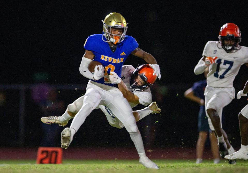 Cardinal Newman Ricky Knight III is pulled down on a return Benjamin defender (6) during their football game on October 20, 2023 in West Palm Beach, Florida.