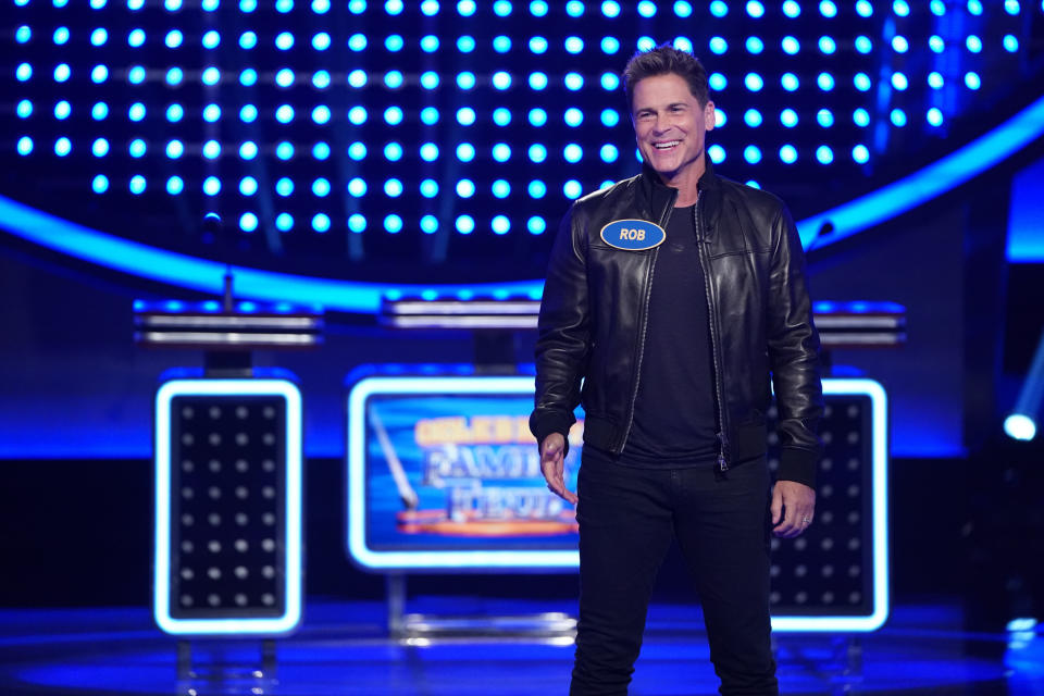 Smiling in a black leather jacket on "Family Feud"