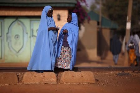 Two girls chat to each other while standing near the railway line in Kaduna state, Nigeria, February 2, 2016. REUTERS/Afolabi Sotunde