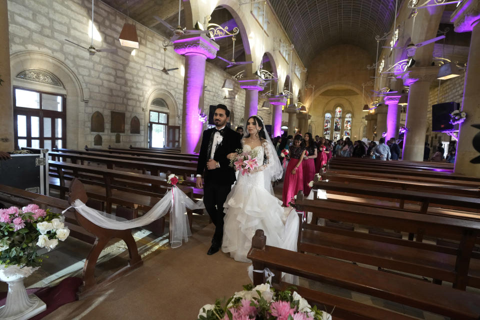 Pakistani Christian groom Sharoon Arjumand John with his bride Yamima Teresa Bhagtaney leave after their wedding ceremony at Holy Trinity Cathedral in Karachi, Pakistan, Saturday, Jan. 27, 2024. Pakistan's winter months are all about weddings. The cooler temperatures between November and February see millions of people attending festivities every week. The wedding season has become a calendar fixture, like birthdays. It even has a nickname, Decemberistan. (AP Photo/Fareed Khan)