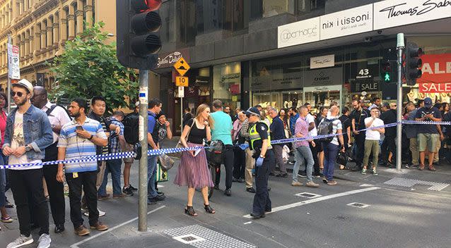 Pedestrians look on after at least 14 pedestrians were struck by a white 4WD. Source: 7 News