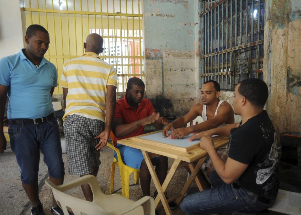 Prisoners play dominoes inside the older wing of the Najayo prison, in the process of renovation, in San Cristobal, May 1, 2014. Ten years after the country opened its first prison designed with a focus on education and clean living conditions and staffed by graduates from a newly created academy for penitentiary studies, the New Model of Prison Management is gaining recognition from other countries in the region trying to reduce prison populations and cut recidivism rates. Picture taken May 1, 2014. REUTERS/Ricardo Rojas (DOMINICAN REPUBLIC - Tags: CRIME LAW POLITICS SOCIETY)