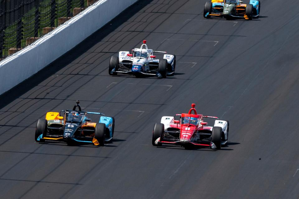 Arrow McLaren SP driver Pato O'Ward (5), left, challenges Chip Ganassi Racing driver Marcus Ericsson (8) as the two race into the first turn after a final restart of the 106th running of the Indianapolis 500, Sunday, May 29, 2022, at The Indianapolis Motor Speedway.