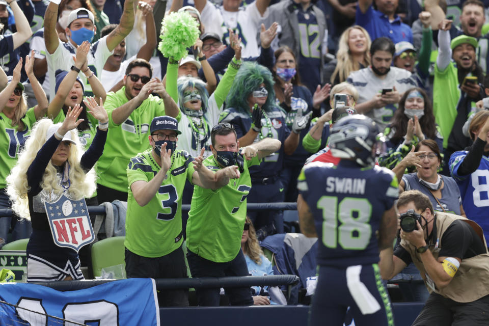 Seattle Seahawks fans react after wide receiver Freddie Swain (18) scored a touchdown against the Tennessee Titans during the second half of an NFL football game, Sunday, Sept. 19, 2021, in Seattle. (AP Photo/John Froschauer)