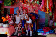 Danusorn Sdisaithaworn (L), 10, and Gorsak Kong Tawan, 13, rest at an altar made for them at their home after an annual Poy Sang Long procession, part of the traditional rite of passage for boys to be initiated as Buddhist novices, in Mae Hong Son, Thailand April 3, 2018. REUTERS/Jorge Silva