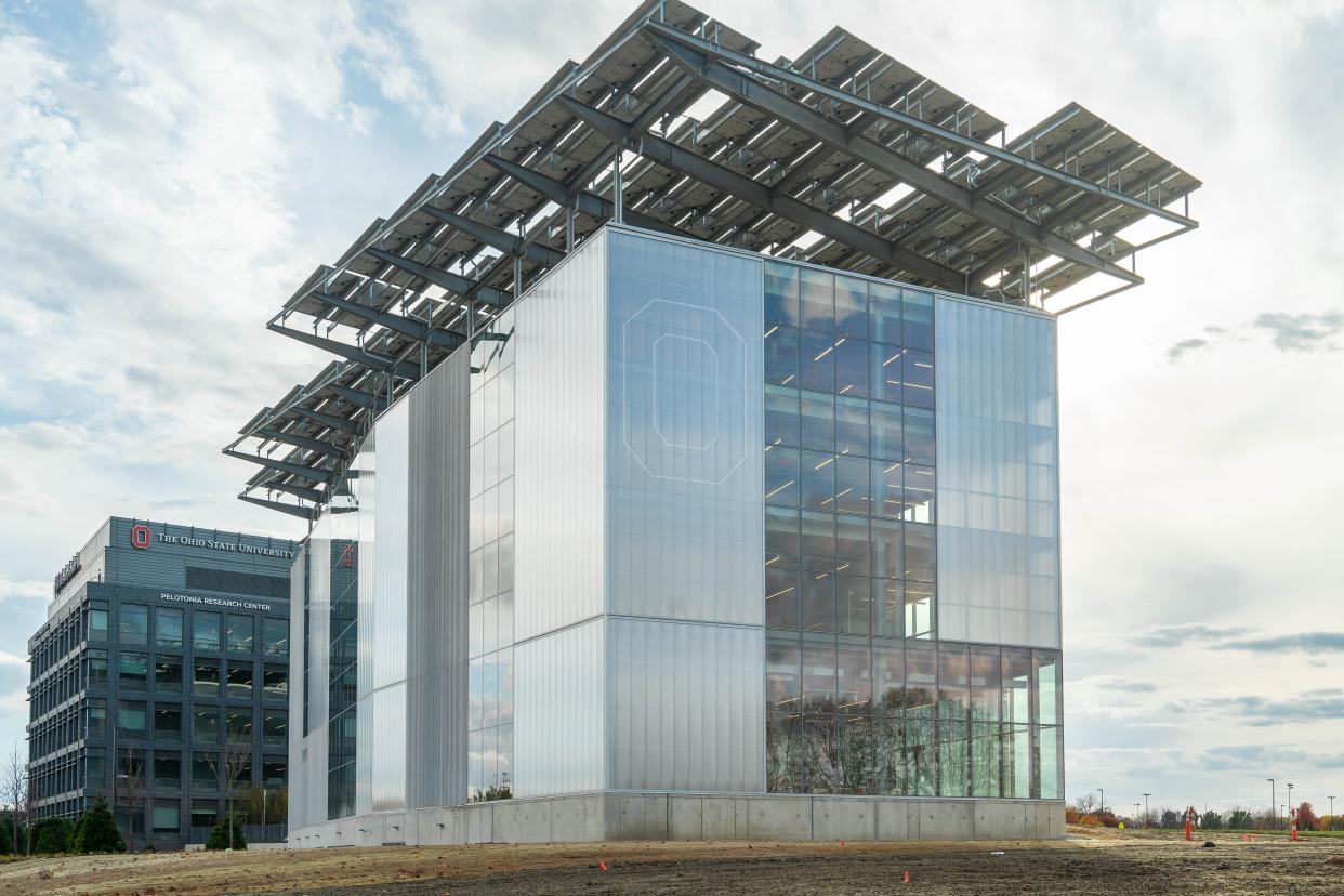 An exterior view of the Energy Advancement and Innovation Center on Carmenton, Ohio State's West Campus Innovation District. At night, a light-up Block O can be seen on the building's exterior.