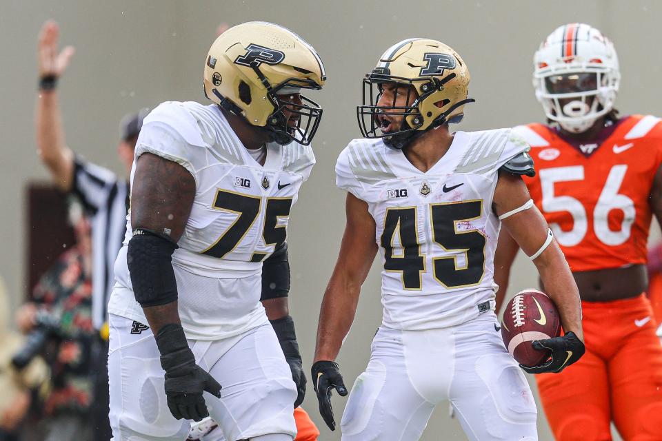 Jalen Grant #75 and Devin Mockobee #45 of the Purdue Boilermakers celebrate after a touchdown against the Virginia Tech Hokies in the first half during a game at Lane Stadium on September 9, 2023 in Blacksburg, Virginia.