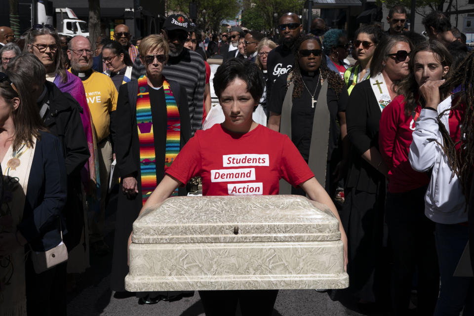 Shannon Felder holds a child's casket before a march to the state Capitol to protest gun violence during a Tennessee Moral Monday rally in Nashville, Tenn., Monday, April 17, 2023. (AP Photo/George Walker IV)