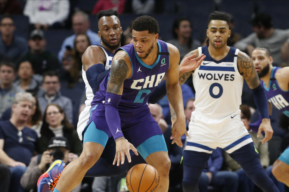 Charlotte Hornets' Miles Bridges, center, controls the ball in front of Minnesota Timberwolves' Josh Okogie, left, and D'Angelo Russell during the first half of an NBA basketball game Wednesday, Feb. 12, 2020, in Minneapolis. (AP Photo/Jim Mone)
